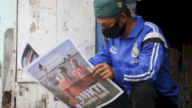 Warga lagi melihat visi-misi dari paslon Danny-Fatma