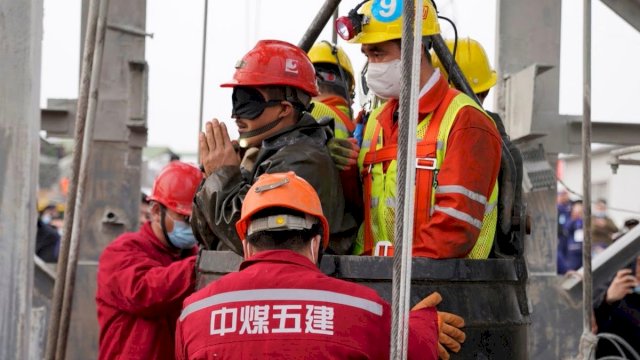 Petugas penyelamat membantu penambang saat ia dibawa ke permukaan di tambang emas setelah ledakan 10 Januari menjebak pekerja di bawah tanah, di Qixia, provinsi Shandong, Cina, 24 Januari 2021. (Foto: Reuters).