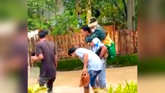 Tangkapan layar video pengantin pria digendong menerobos banjir menuju rumah pengantin wanita di Kabupaten Barru, Sulawesi Selatan. 