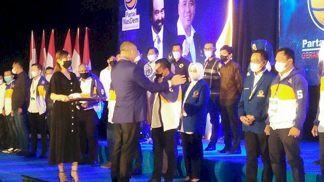 Waketum DPP Partai NasDem, Ahmad Ali, memaikan jaket dan jas NasDem untuk kader baru resmi bergabung. 