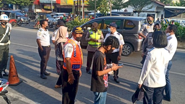 Petugas Dishub Kota Makassar menggembok sejumlah kendaraan yang parkir sembarangan di Jalan Pengayoman. 