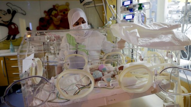 Seorang perawat merawat salah satu bayi yang baru lahir, terbaring di inkubator, di klinik swasta Ain Borja di Casablanca, Maroko, 5 Mei 2021. Foto: REUTERS