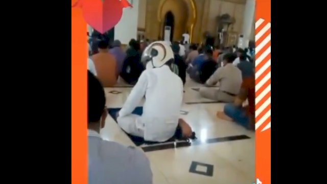 Tangkapan layar video viral pria salat pakai helm. 