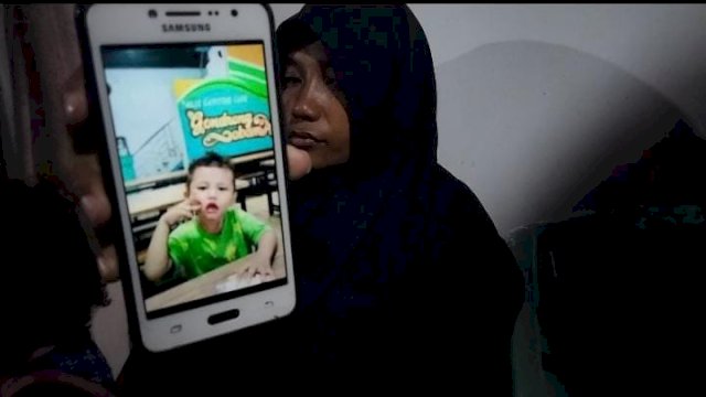 Ibunda Muhammad Rehan Saputra, saat menunjukkan foto anaknya kepada wartawan.