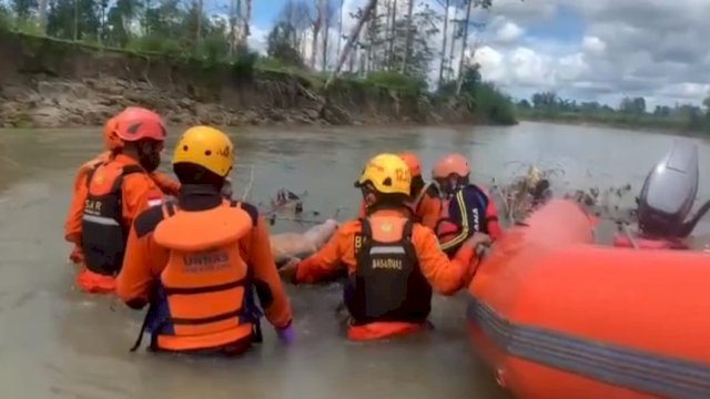 Petugas Basarnas saat melakukan evakuasi terhadap jasad wanita yang ditemukan tewas di sungai Luwu Utara, Sulsel.