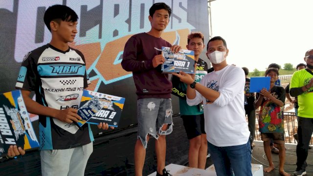 Pembalap dari RMS Racing Team, Angga Sapurede menerima hadiah dalam Kejuaraan Grasstrack dan Motocross 2021 Makassar