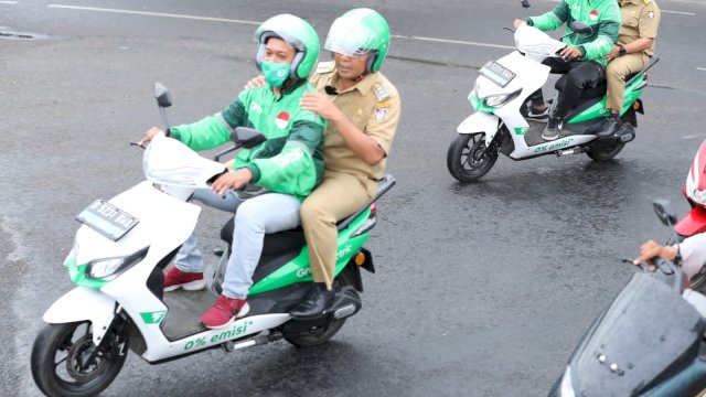 Gunanakan Ojol Grab ke Lokasi Kegiatan, Walikota Danny Terobos Hujan Pakai Motor