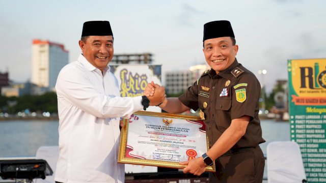 Pj Gubernur Sulsel Bahtiar Baharuddin Menyerahkan Penghargaan ke Kajati Sulsel Leonard Eben Ezer Simanjuntak. (Foto: Humas Pemprov Sulsel)