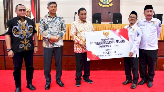Pj Gubernur Sulsel Bahtiar Baharuddin (tengah) Menyerahkan Zakat ASN ke Kepala Baznas Sulsel Khidri Alwi (kanan).