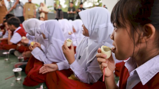 Kegiatan Makan Telur oleh Siswa SD.