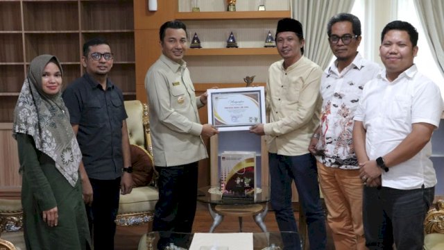 KPU Luwu Utara Serahkan Piagam Apresiasi Kepada Bupati Andi Rahim.