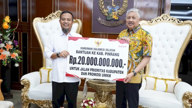 Gubernur Sulsel, Andi Sudirman Sulaiman, menyerahkan bantuan keuangan ke Bupati Pinrang, Andi Irwan Hamid.