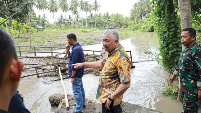 Bupati Pinrang, Irwan Hamid, turun langsung meninjau lokasi jembatan yang rusak di Dusun Karajo, Desa Sabbangparu, Kecamatan Lembang.