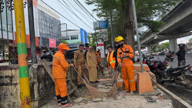 Petugas kebersihan kecamatan Panakkukang melakukan pembersihan di Jalan Andi Pangerang (AP) Pettarani, Makassar.